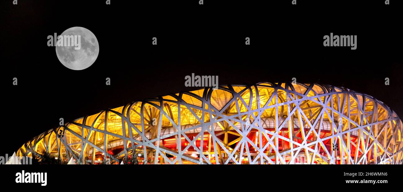Moon sorge sullo stadio olimpico Bird’s Nest (Beijing National) di notte Foto Stock