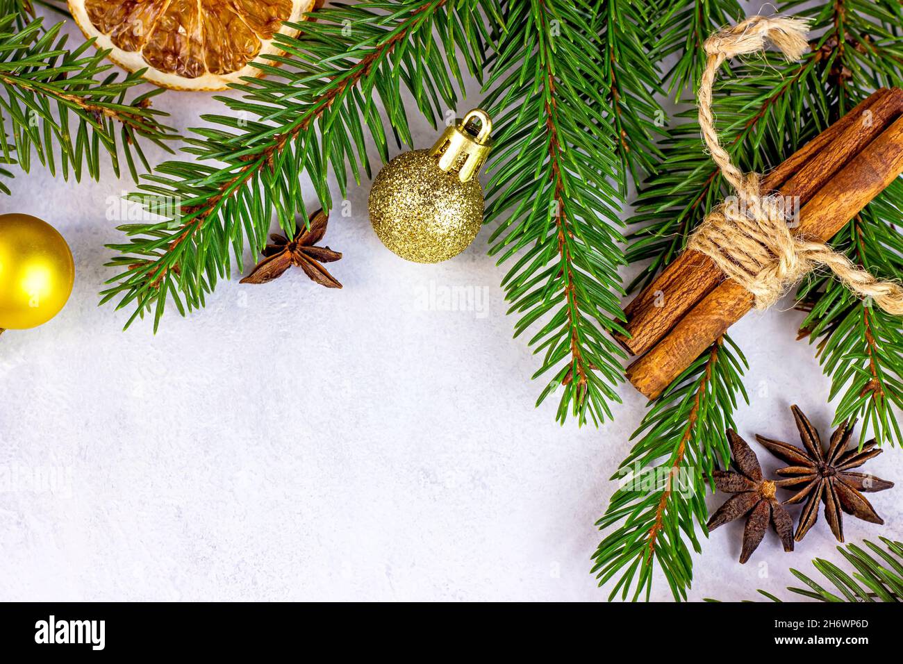 Rami di abete verde di Natale, baubles d'oro, arance e spezie come cornice di corona stagionale di Natale su sfondo bianco per biglietti d'auguri. Tradizione Foto Stock