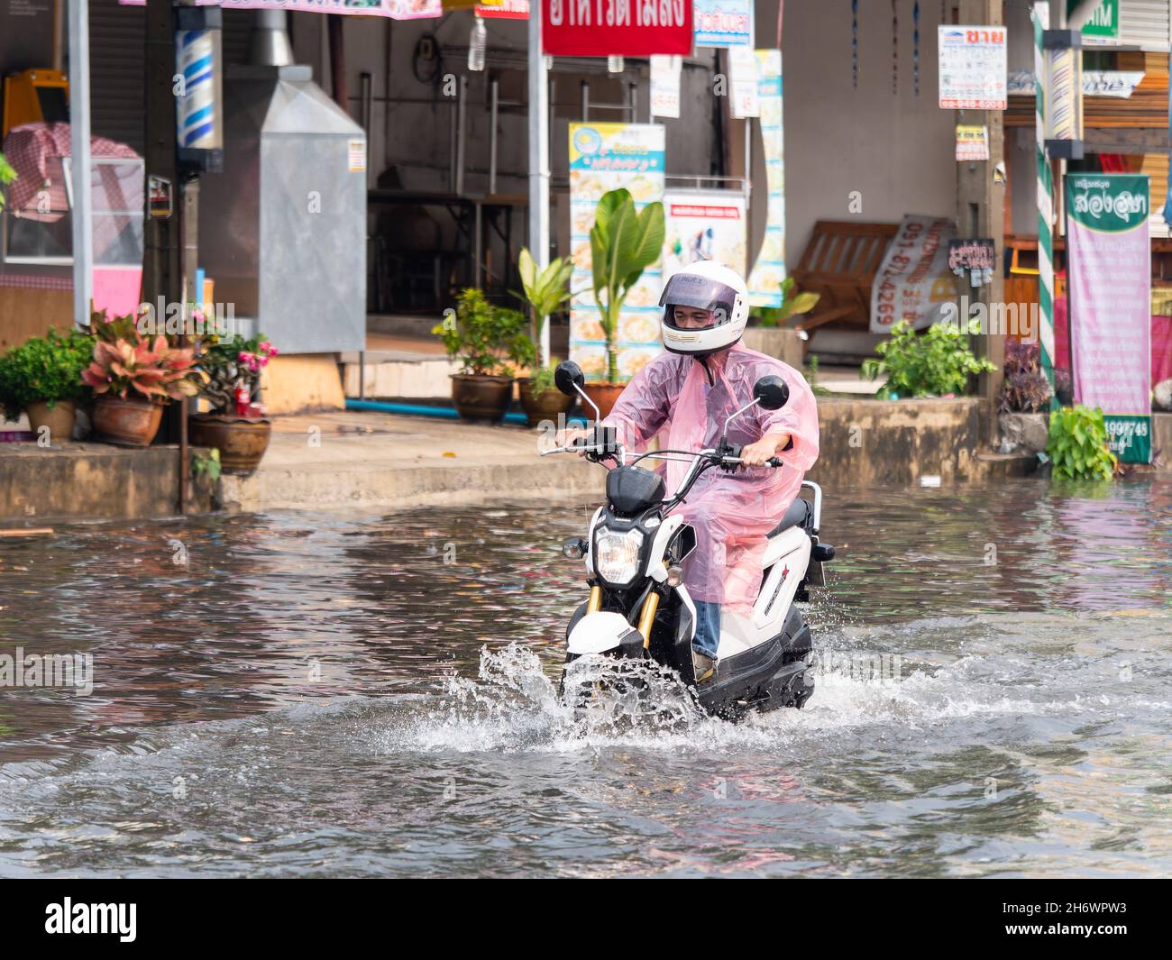 Moto su strada allagata nella provincia di Samut Prakan in Thailandia Foto Stock