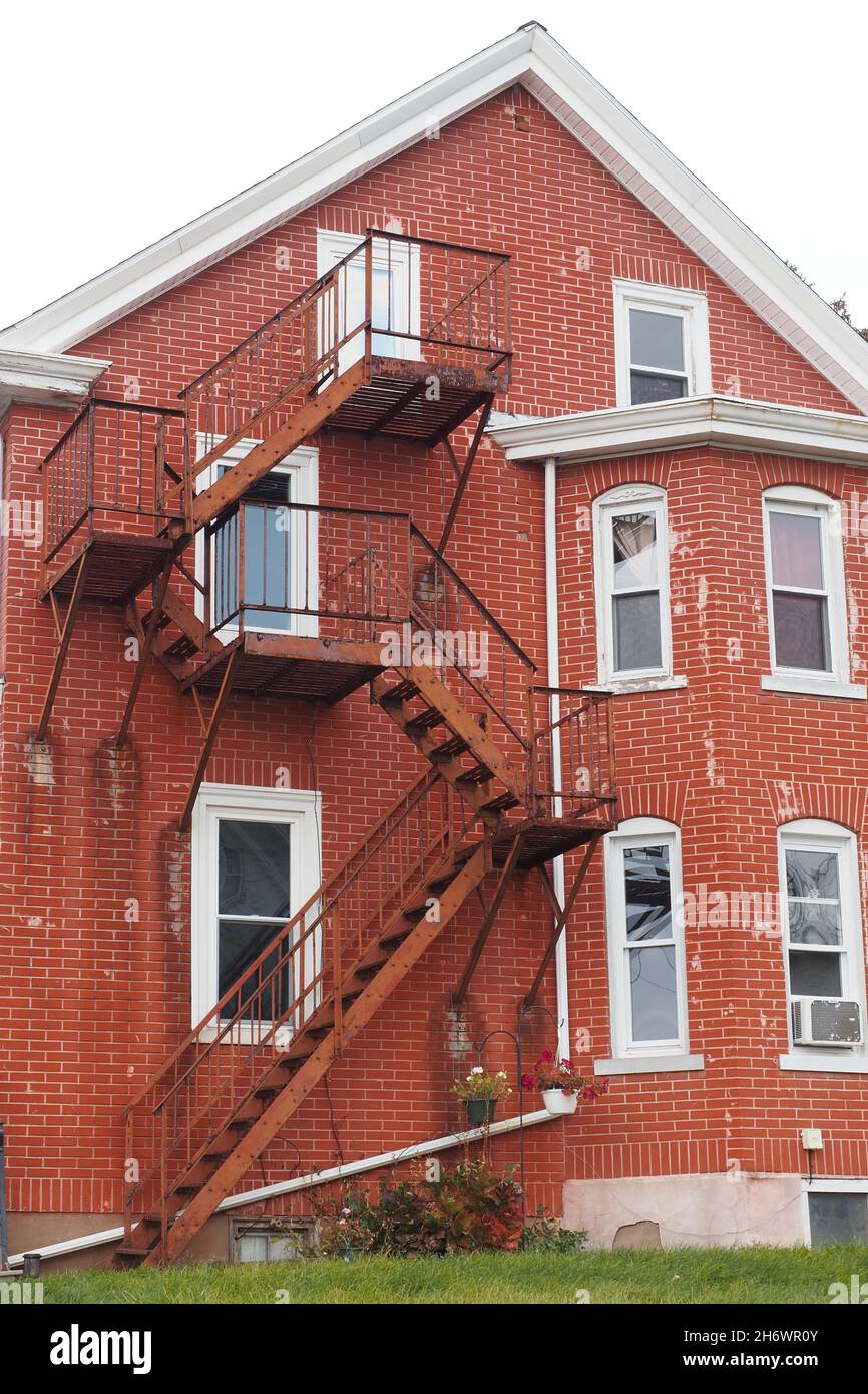 La fuga del fuoco è dipinta di rosso per combaciare con i mattoni dell'edificio. Foto Stock