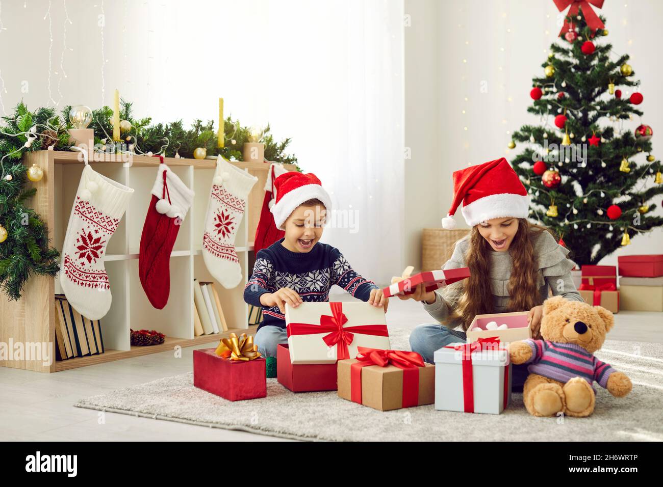 I bambini felici disimballano i regali su nuovo anno Foto Stock