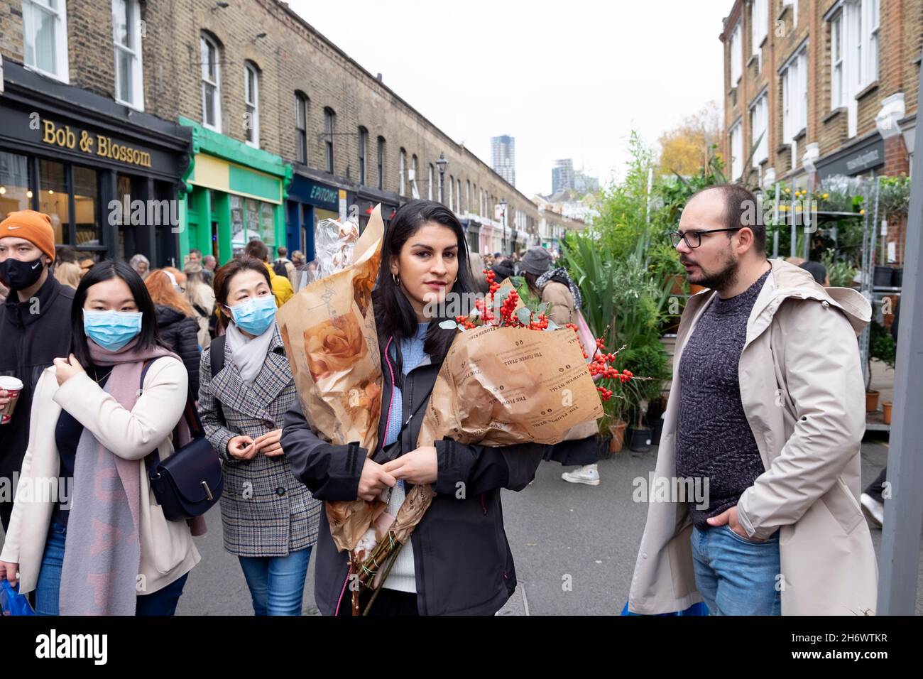 Columbia Road Flower Market persone che acquistano piante fiori in strada al mercato bancarelle Domenica nel novembre 2021 East London UK KATHY DEWITT Foto Stock