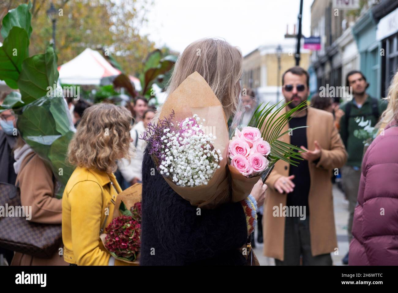 Columbia Road Flower Market persone che acquistano piante fiori in strada al mercato bancarelle Domenica nel novembre 2021 East London UK KATHY DEWITT Foto Stock