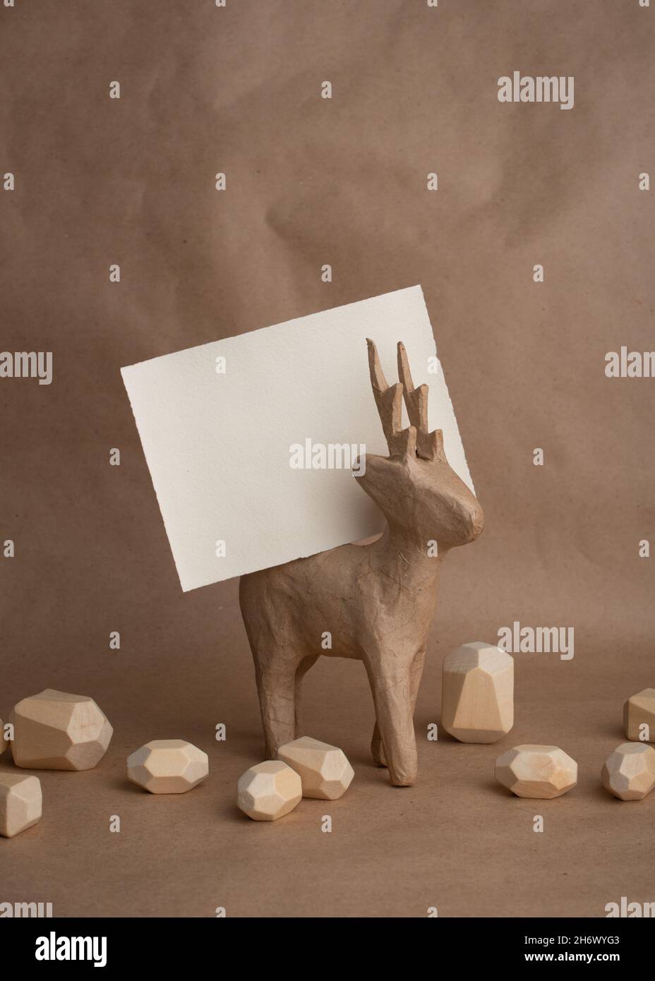 Concetto di Natale monocromatico minimo. Cervi di carta con biglietto vuoto per i vostri saluti. Stile Scandinavo. Foto Stock