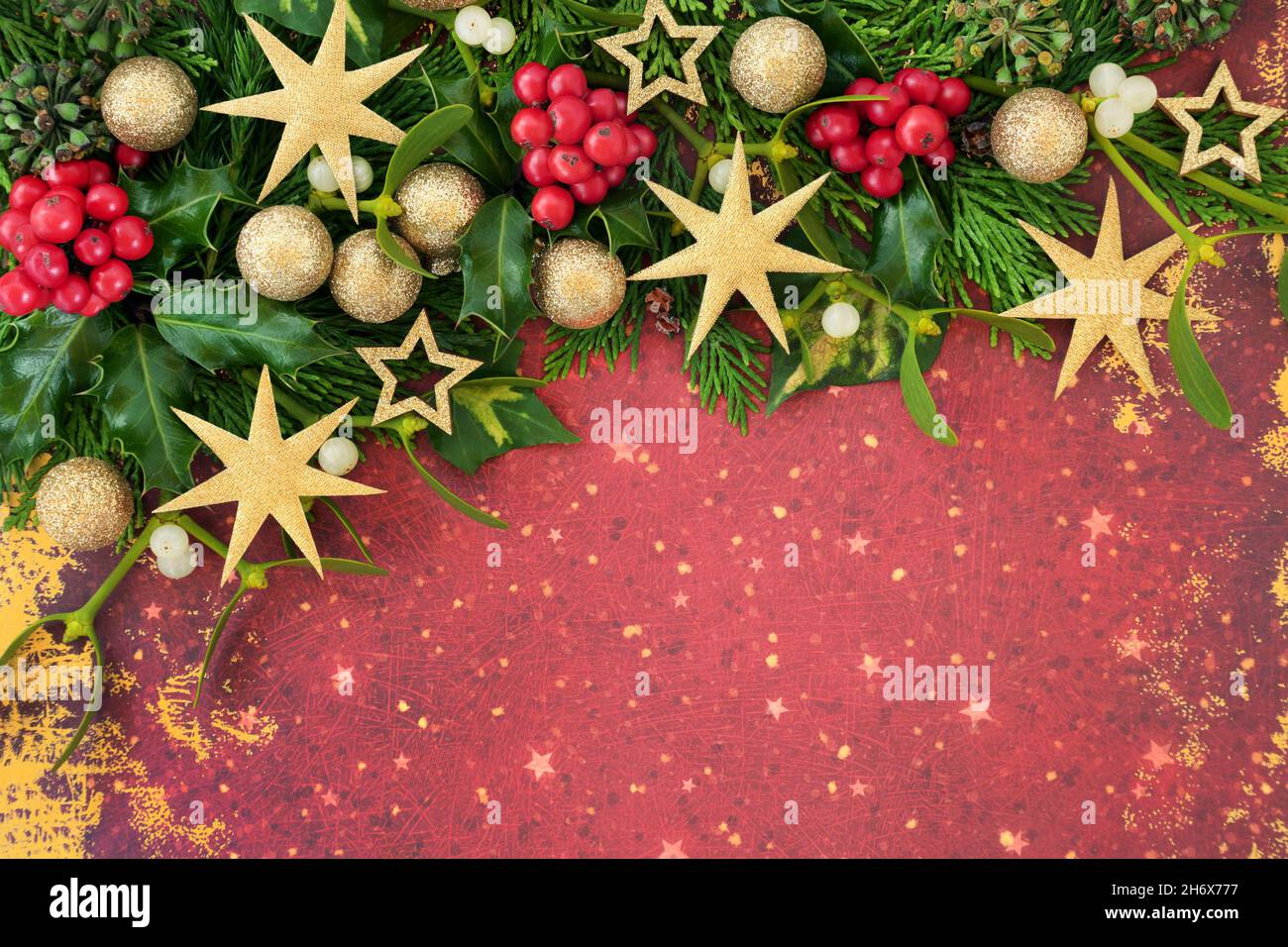 Sfondo di Natale bordo astratto composizione con agrifoglio, cedro, edera e oro glitter albero decorazioni. Design festivo per la stagione delle feste. Foto Stock