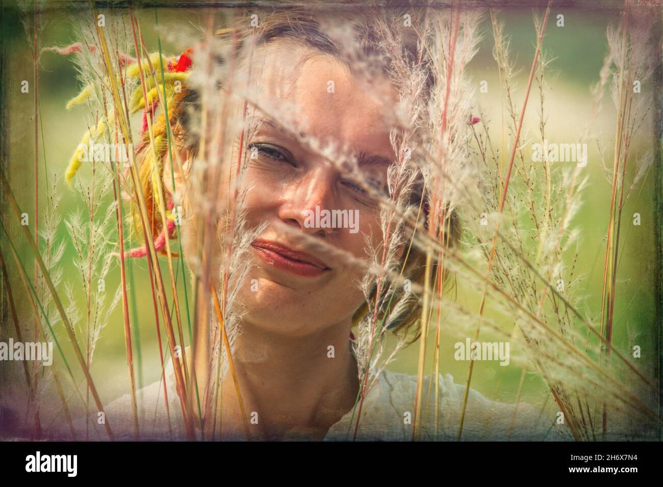 donna di 30-35 anni in erba piuma vicino al fiume Foto Stock