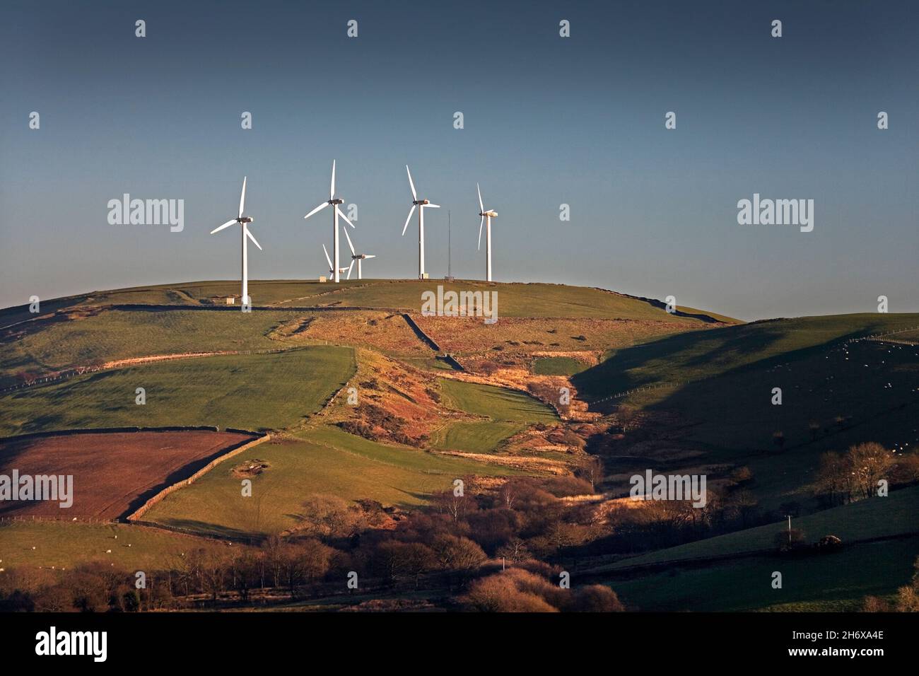 Wind farm sulla cima della montagna alla luce della sera Foto Stock