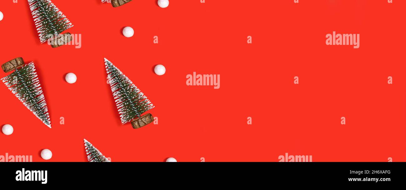 Banner rosso di Natale con alberi e palle di neve su sfondo rosso con spazio copia Foto Stock