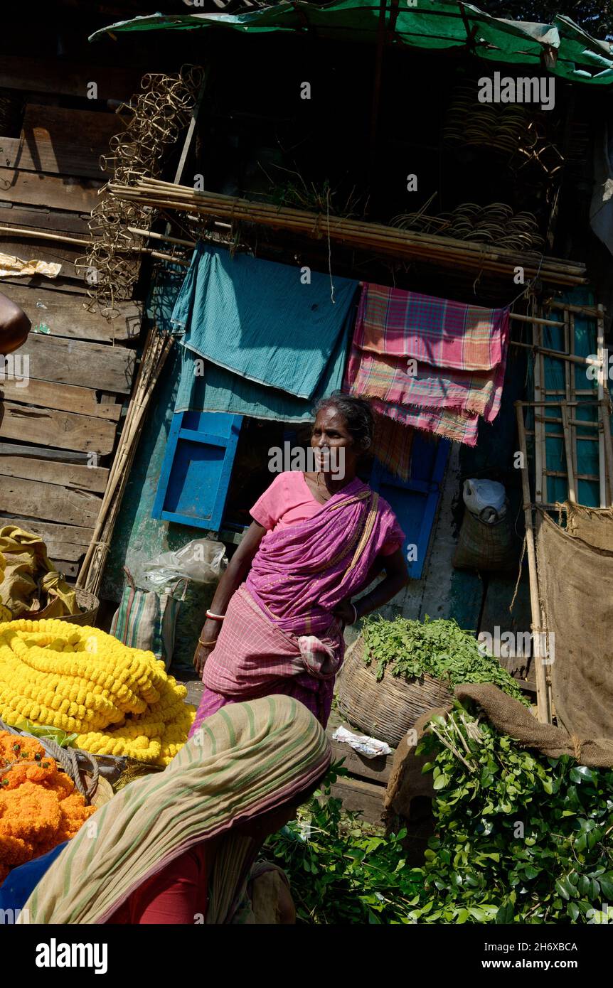 Fiorista donna indiana matura che vende fiori nel mercato dei fiori di Howrah Calcutta Foto Stock