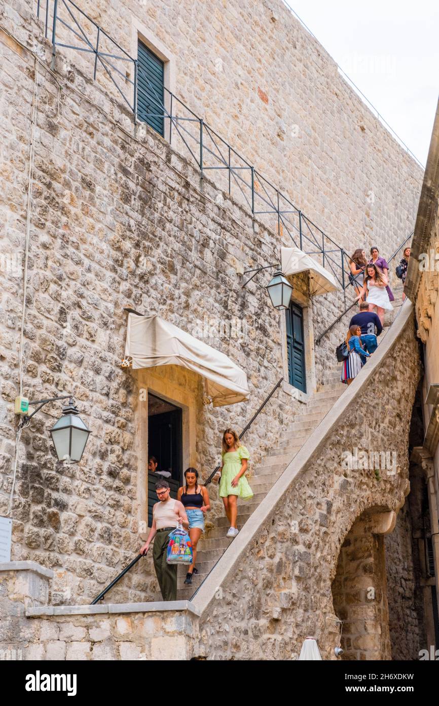 Turisti che si arrampicano per e da mura della città, Grad, città vecchia, Dubrovnik, Croazia Foto Stock