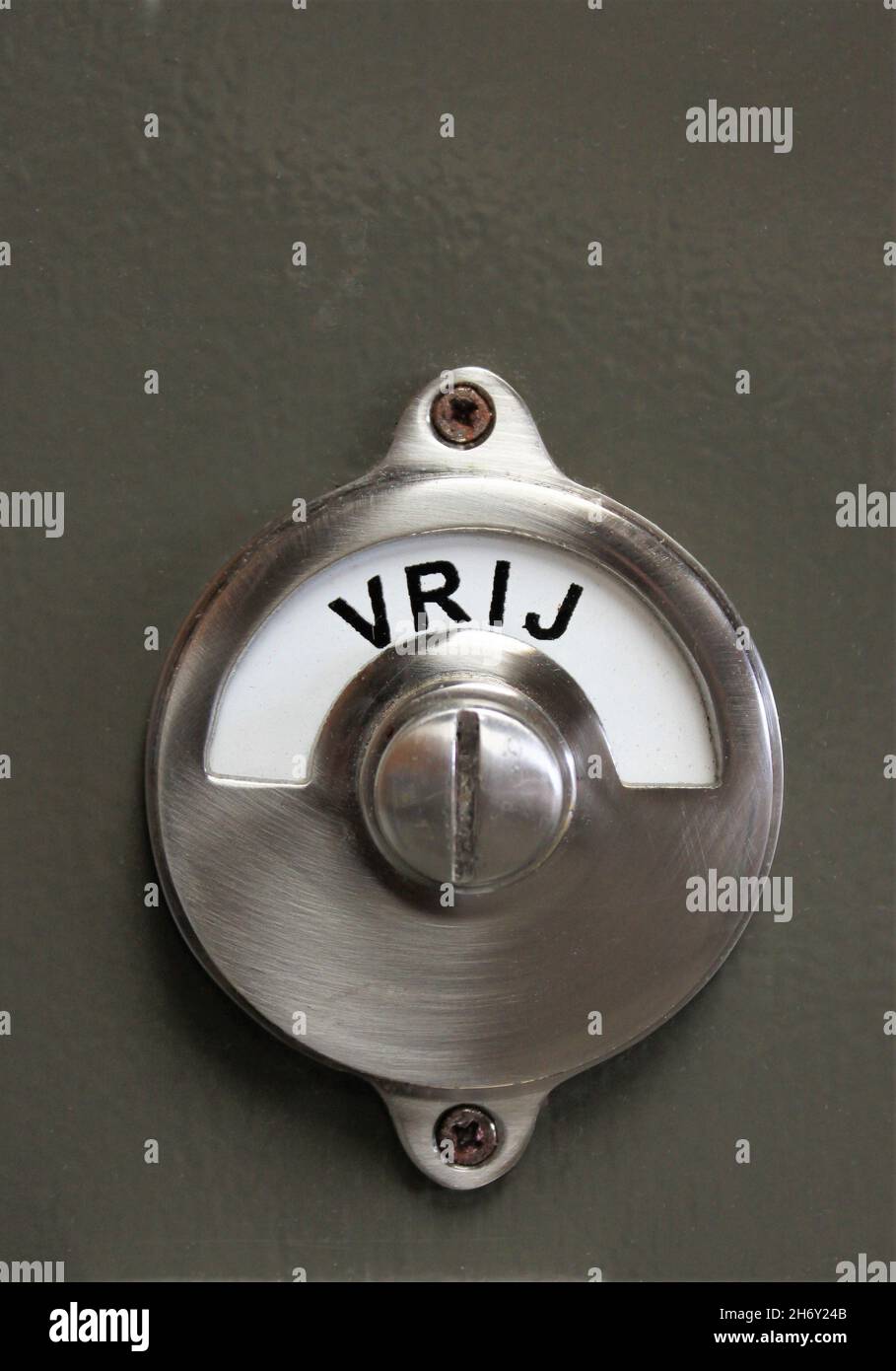Un cartello girevole in metallo su una porta con l'iscrizione olandese Vrij, che significa non occupato Foto Stock