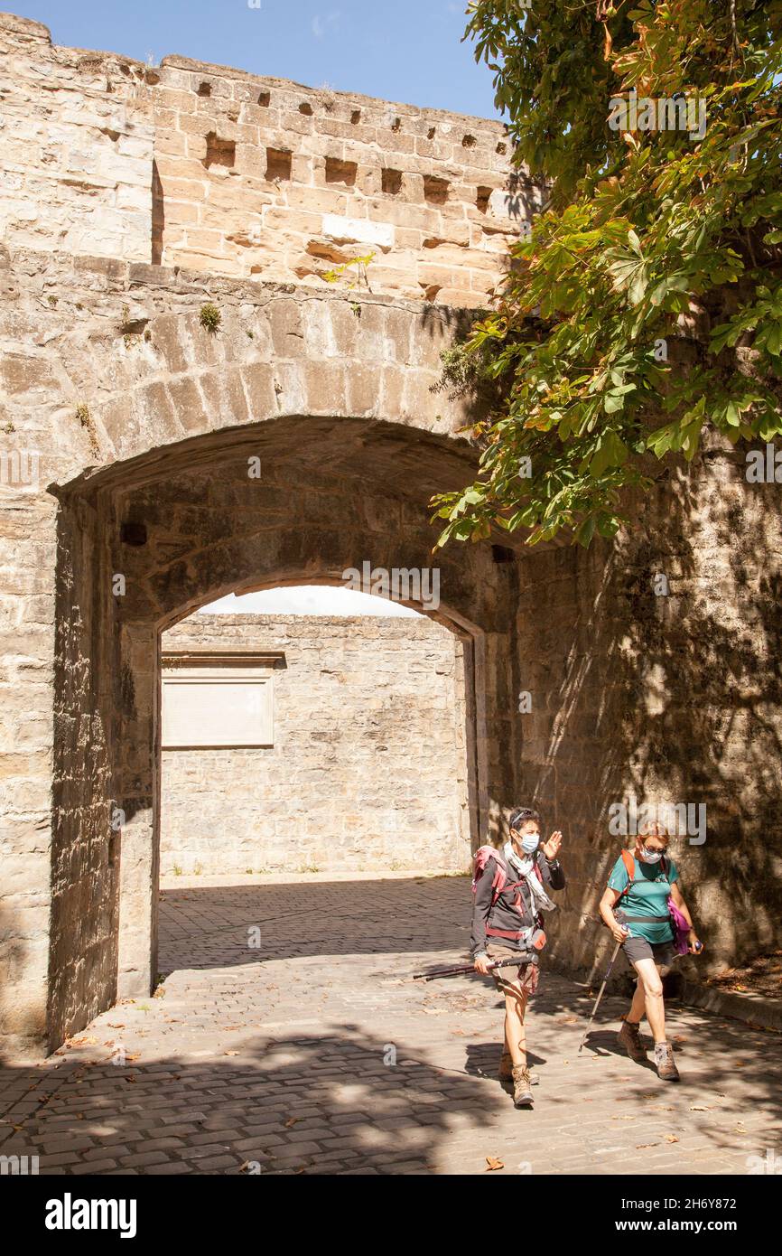 Pellegrini che camminano attraverso le porte della città a Camino de Santiago la via del pellegrinaggio di San Giacomo attraverso la città spagnola di Pamplona Navarra Spagna Foto Stock