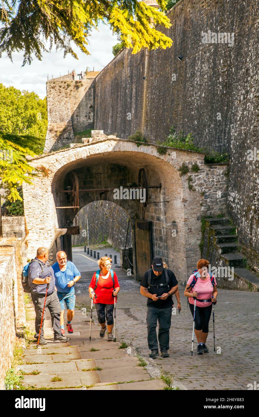 Pellegrini che camminano attraverso le porte della città a Camino de Santiago la via del pellegrinaggio di San Giacomo attraverso la città spagnola di Pamplona Navarra Spagna Foto Stock