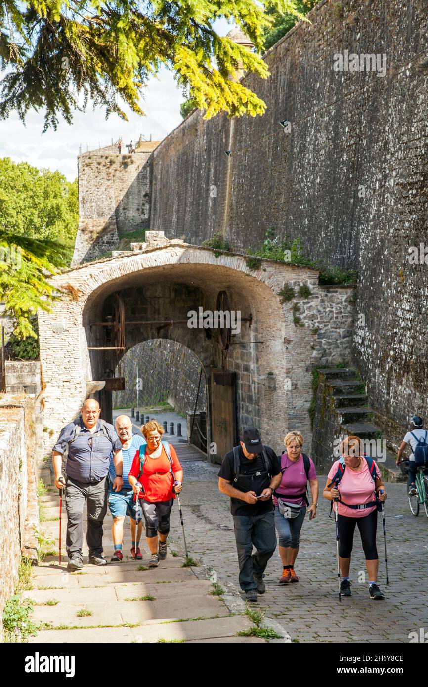 Pellegrini che camminano attraverso le porte della città a Camino de Santiago la via del pellegrinaggio di San Giacomo attraverso la città spagnola di Pamplona Navarra Spagna Foto Stock