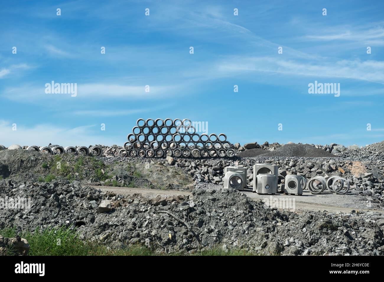 Cantiere di costruzione con tubi di cemento impilati sullo sfondo Foto Stock