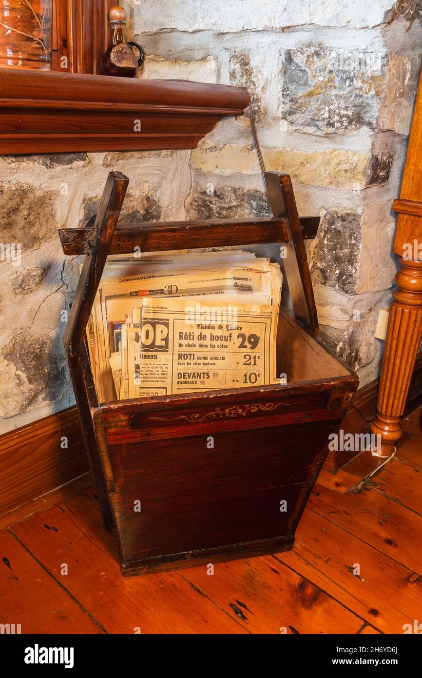 Antico vassoio di giornali in legno colorato marrone con vecchi quotidiani degli anni '30, '40, '50 in sala da pranzo all'interno di una vecchia casa Canadiana circa 1750 fieldstone Foto Stock