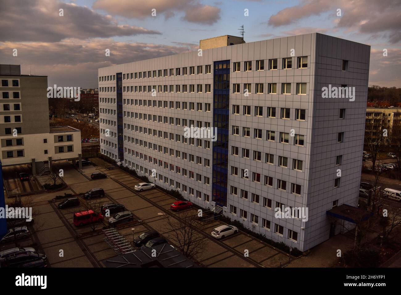Piazza edificio alberghiero minimalista in blu nel pomeriggio con alcune auto parcheggiate a Berlino, Germania Foto Stock