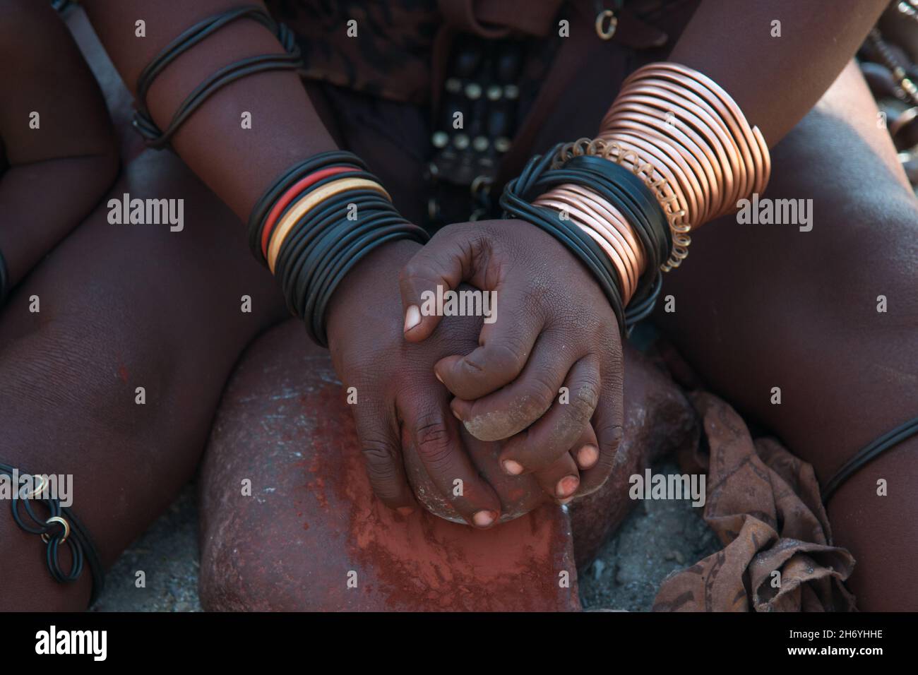 Donna irriconoscibile della tribù himba che lavora con argilla nelle sue mani. L'argilla è usata per proteggere i capelli e la pelle. Regione di Epupa, Namibia. Africa Foto Stock