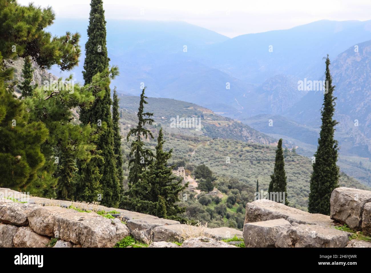 Vista dal sito archeologico di montagna dell'antica Delfi Grecia guardando verso la valle e al Tempio di Athena sotto Foto Stock