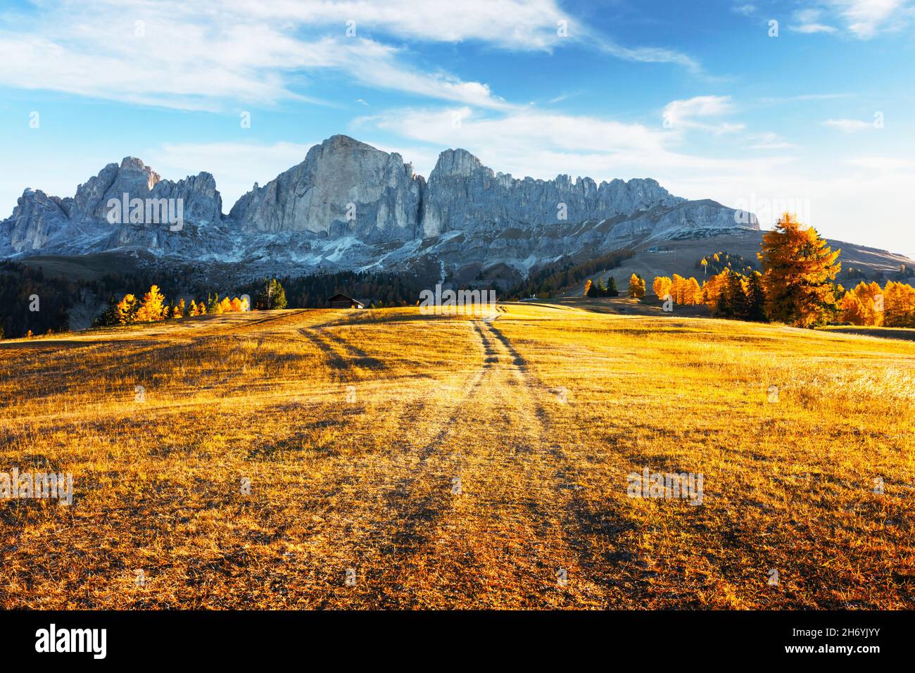 Bel paesaggio rurale italiano con prato autunnale, casa in legno e cime di alte montagne sullo sfondo. Passo Nigerpass (Passo Nigra), Alpi dolomitiche, Dolomiti, Italia Foto Stock