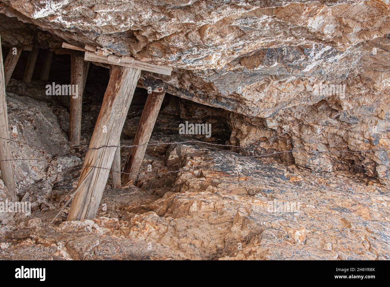 Tonopah, Nevada, USA - 18 maggio 2011: Storico Parco minerario. Primo piano di una vecchia entrata della miniera con rocce marrone-beige con borchie per sostenere il tetto. Foto Stock