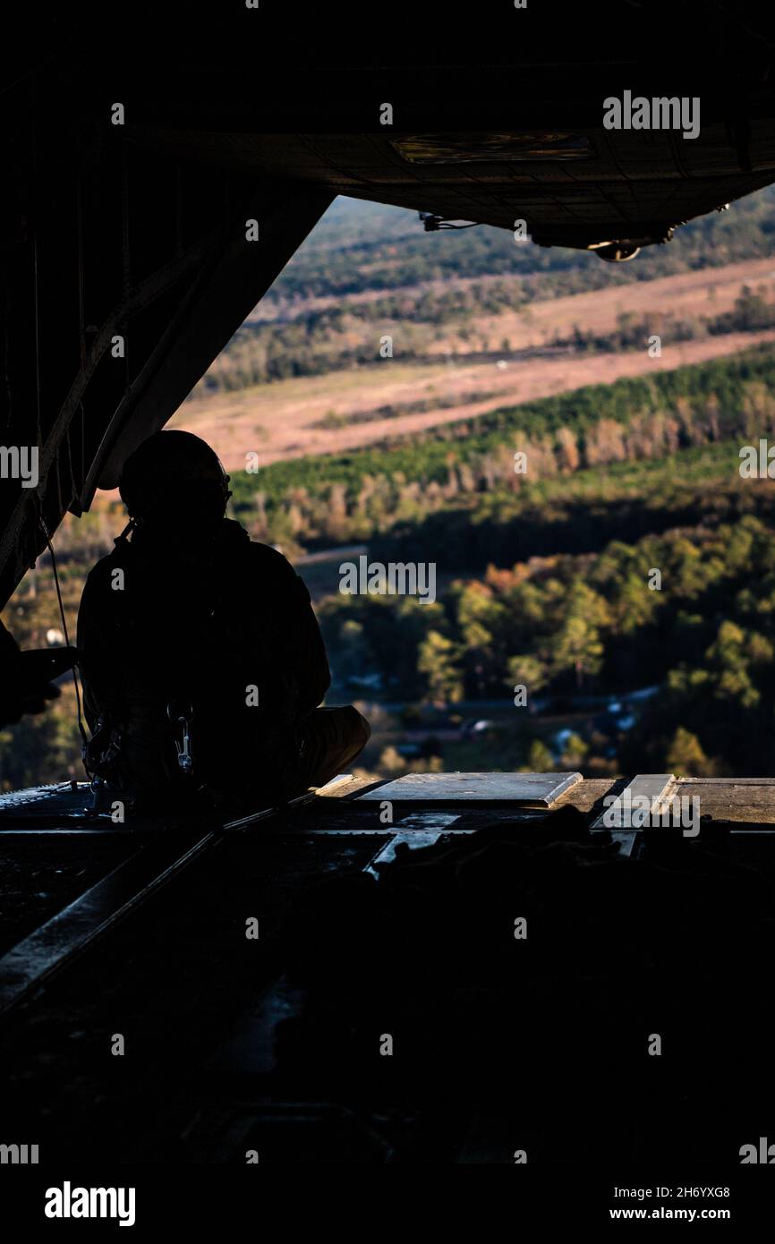 Un membro dell'equipaggio di elicotteri Marine Corps CH-53 'Sea Stallion' si affaccia sulla zona di discesa Bemiss alla Moody Air Force base, Georgia, 16 novembre 2021. Gli Airmen del Gruppo di Difesa di base 820 insieme ai soldati della Guardia Nazionale dell'Esercito della Georgia e ai membri dell'equipaggio di elicotteri del corpo Marino CH-53 hanno condotto la formazione delle operazioni aeree per scambiare tattiche, tecniche e procedure da tre rami dell'esercito e per rafforzare le capacità di missione di lavoro di combattimento agile congiunto. (STATI UNITI Air Force foto di 1 Lt. Katie Tamesis) Foto Stock