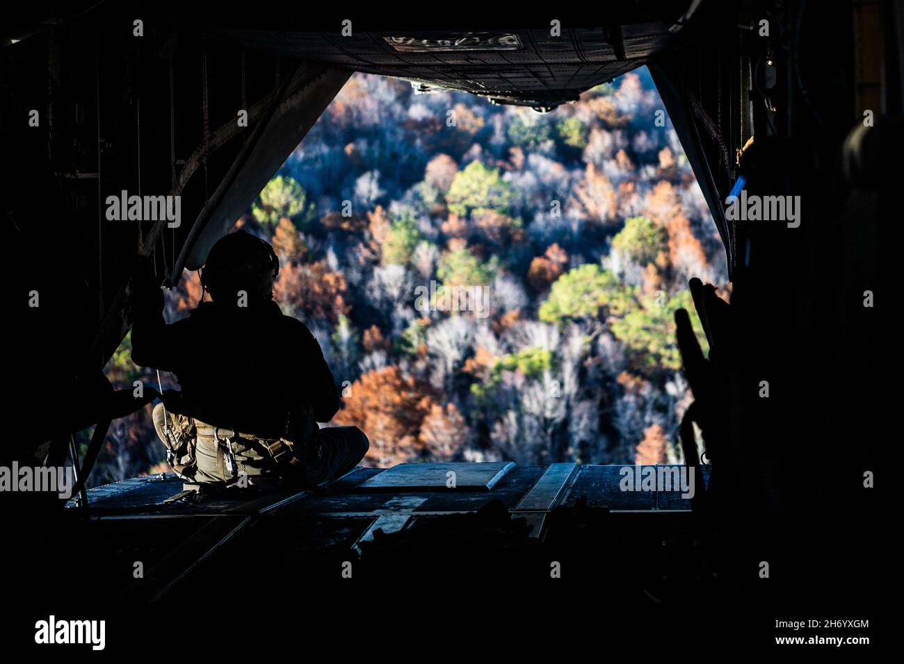 Un membro dell'equipaggio di elicotteri Marine Corps CH-53 'Sea Stallion' si affaccia sulla zona di discesa Bemiss alla Moody Air Force base, Georgia, 16 novembre 2021. Gli Airmen del Gruppo di Difesa di base 820 insieme ai soldati della Guardia Nazionale dell'Esercito della Georgia e ai membri dell'equipaggio di elicotteri del corpo Marino CH-53 hanno condotto la formazione delle operazioni aeree per scambiare tattiche, tecniche e procedure da tre rami dell'esercito e per rafforzare le capacità di missione di lavoro di combattimento agile congiunto. (STATI UNITI Air Force foto di 1 Lt. Katie Tamesis) Foto Stock