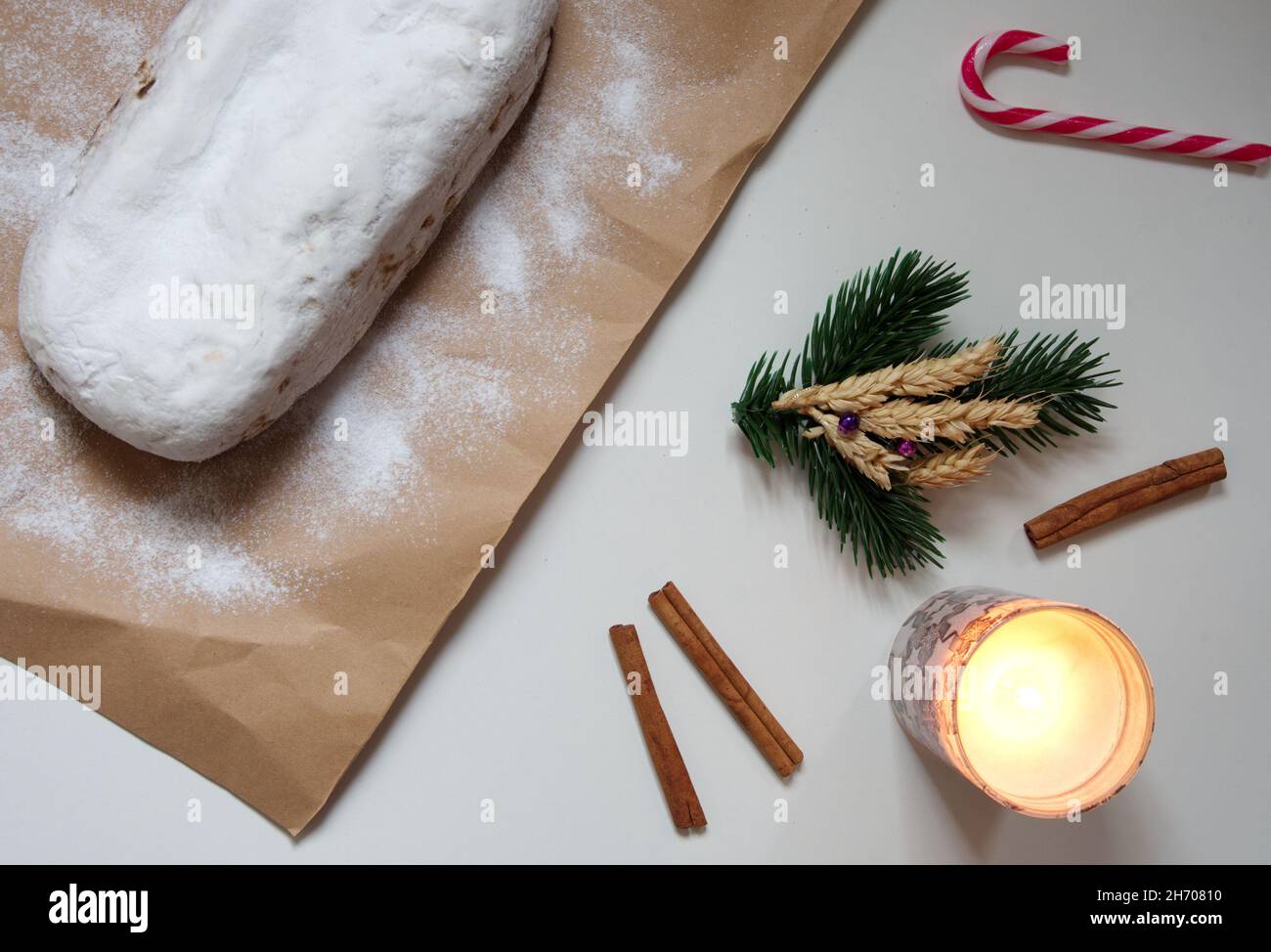 Piatto di pane di Natale con cannella, cannella e candela su sfondo bianco Foto Stock