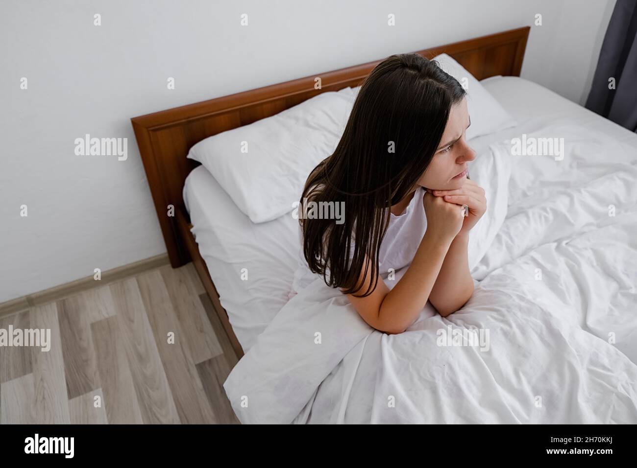Depressione e problemi psicologici, giovane signora turbata seduta a letto solo sentire stress ansia dopo cattivo sonno incubo sogno concetto Foto Stock