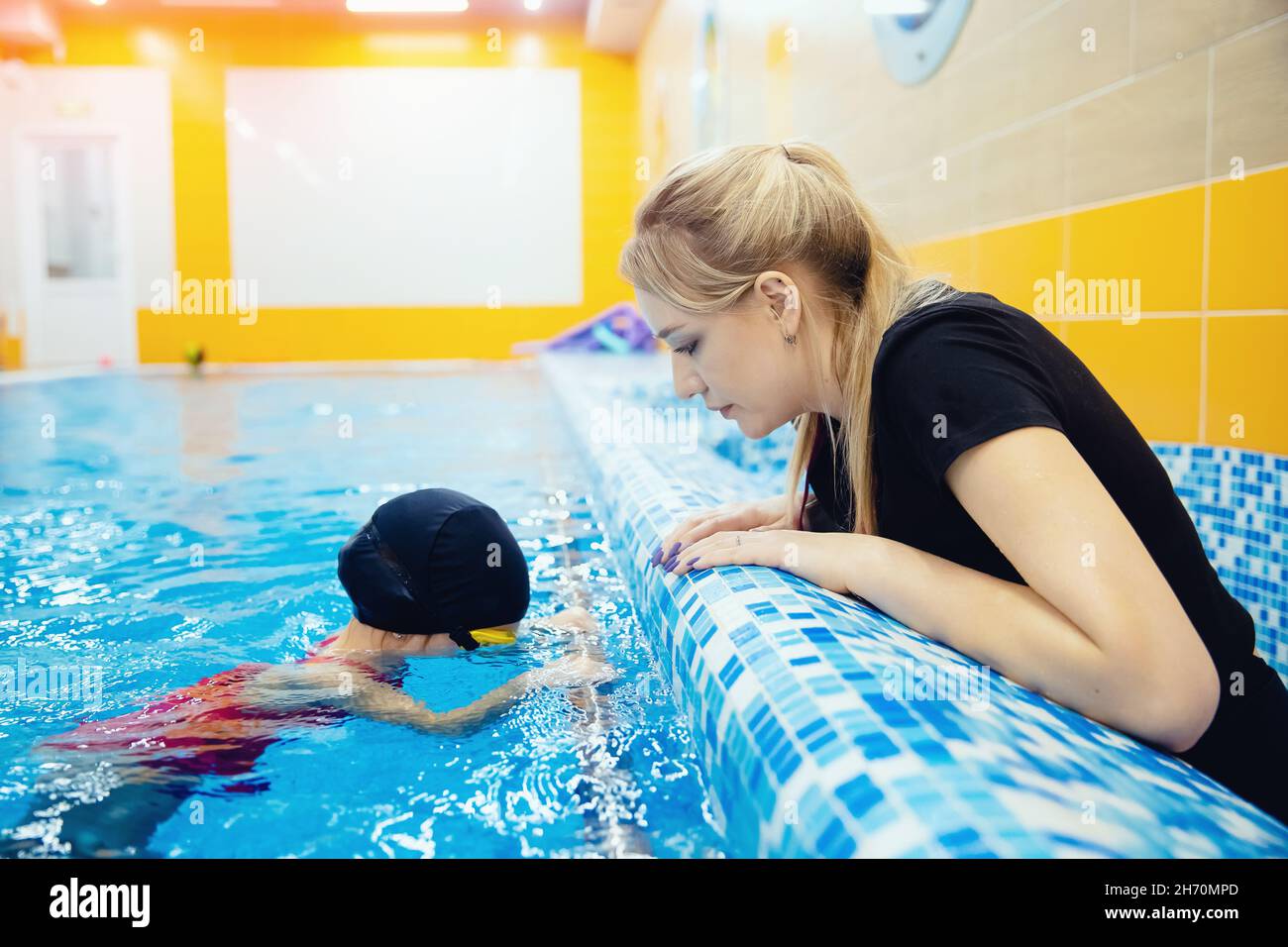 Allenatore donna di squadra e atleta bambino in piscina, scuola di  allenamento nuoto per bambini Foto stock - Alamy