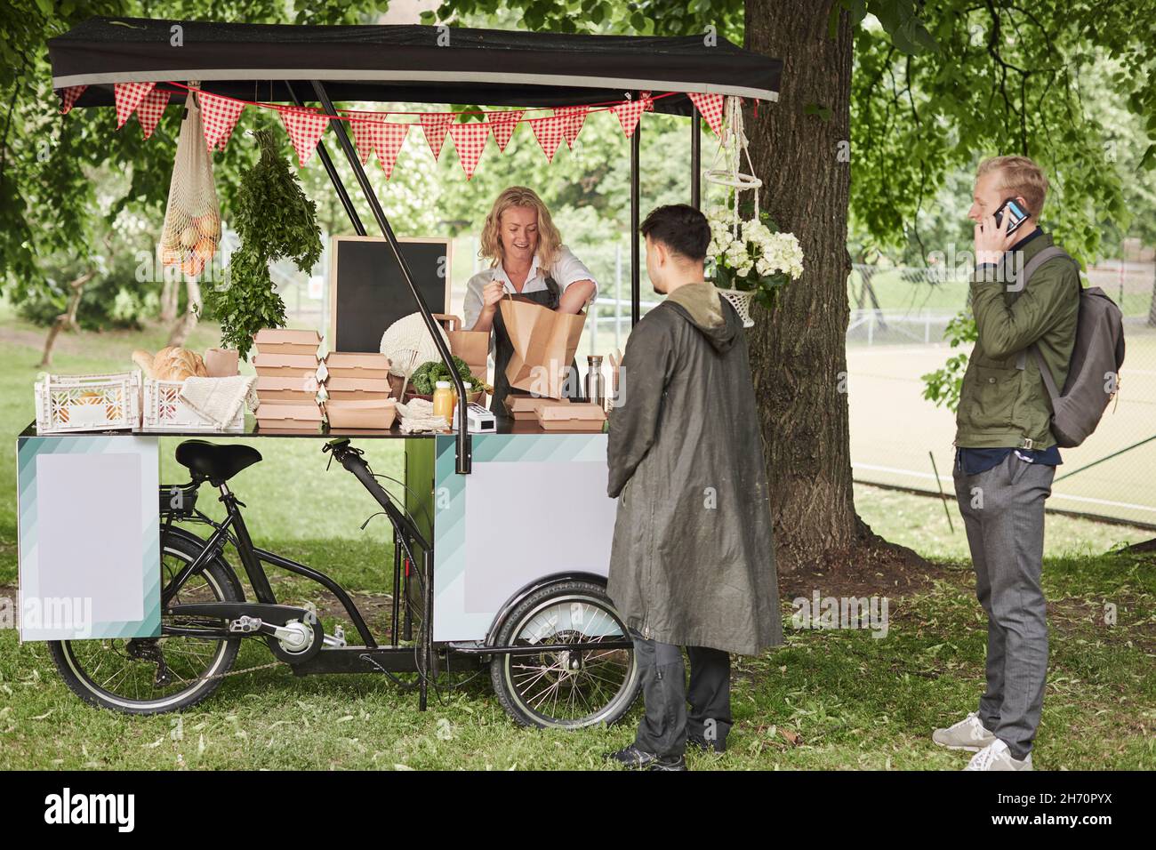 I clienti che acquistano cibo alla bancarella del cibo Foto Stock