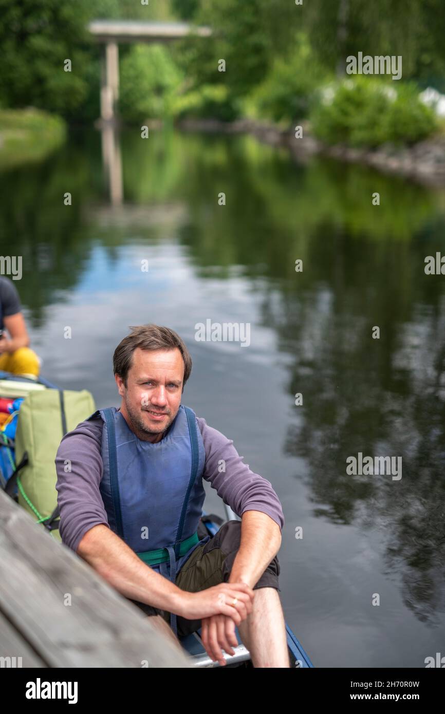 Uomo sorridente seduto in kayak Foto Stock