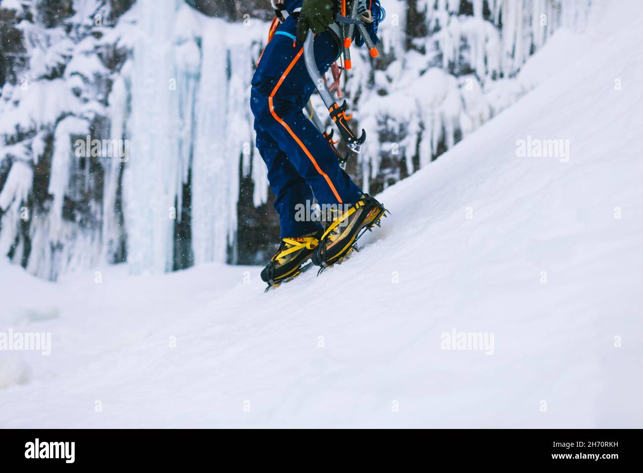 Gambe di arrampicatore di ghiaccio che indossano ramponi Foto Stock