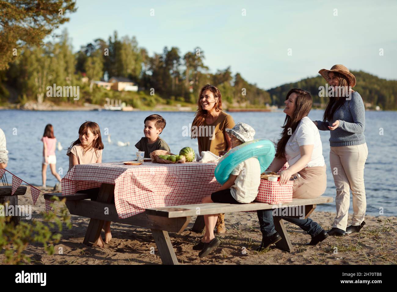 Famiglia che ha un picnic al lago Foto Stock