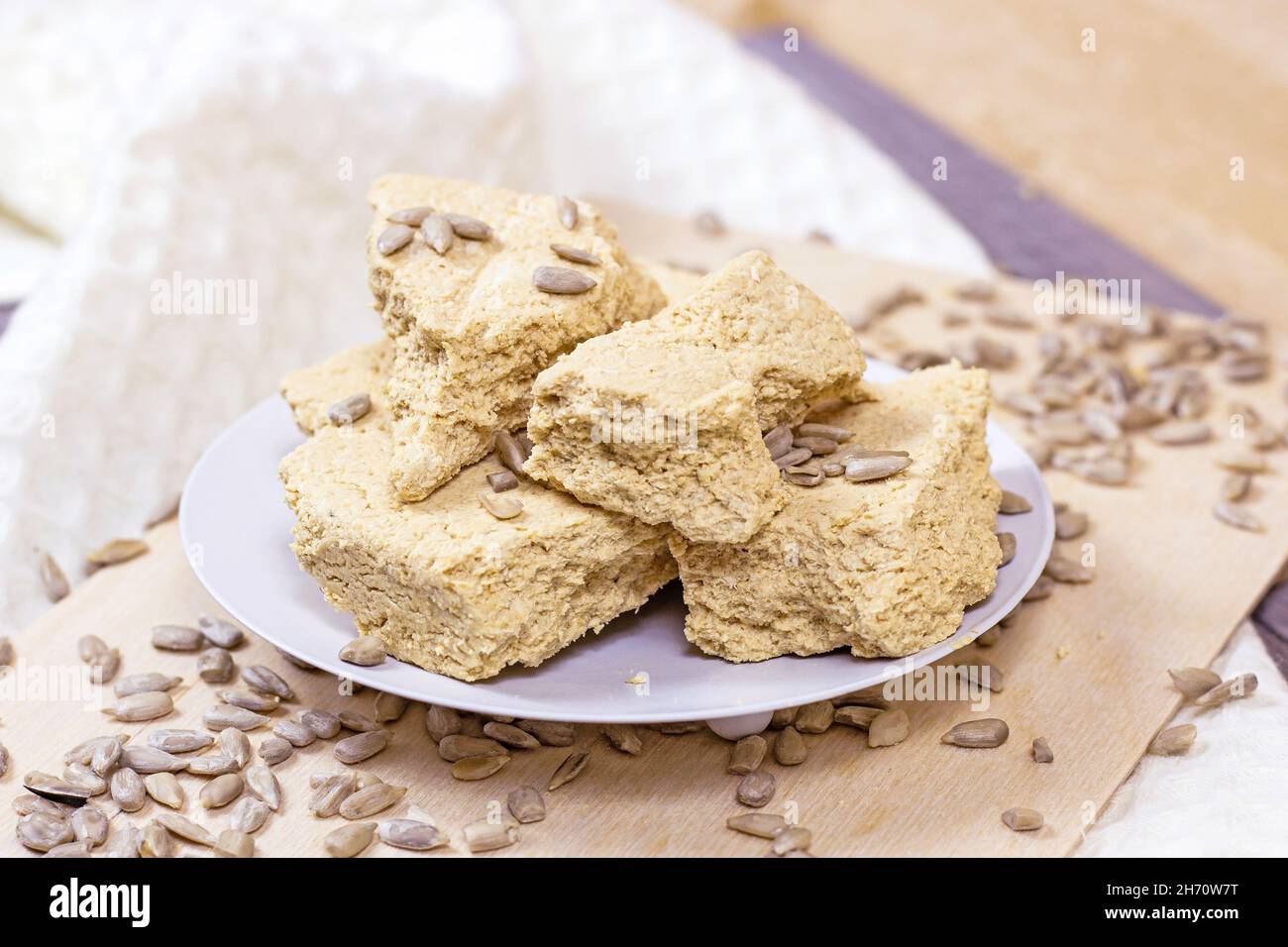 Tradizionali pezzi di halva dolce turco delizia con semi di girasole su sfondo chiaro. Foto Stock