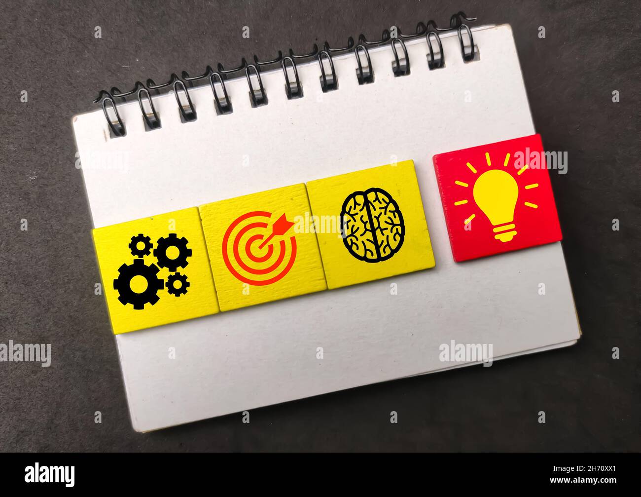 Notebook, cubi colorati con icone, idee e obiettivi di gestione. Business concept Foto Stock