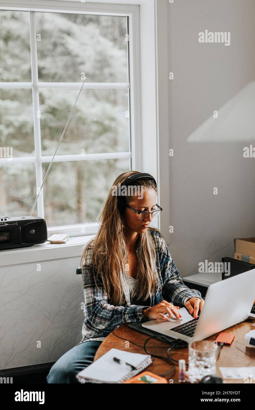 Donna con notebook in cucina Foto Stock