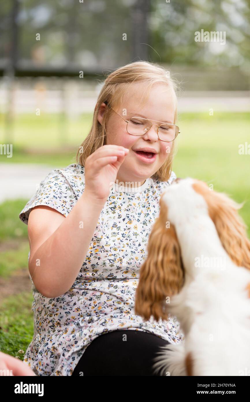 Ragazza sorridente che dà il regalo al cane Foto Stock