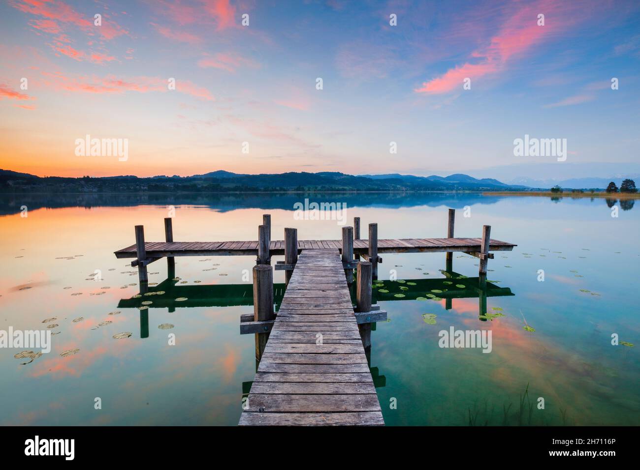 Molo di legno sul lago Pfaeffikersee all'alba. Pfaeffikon, Cantone di Zurigo, Svizzera Foto Stock