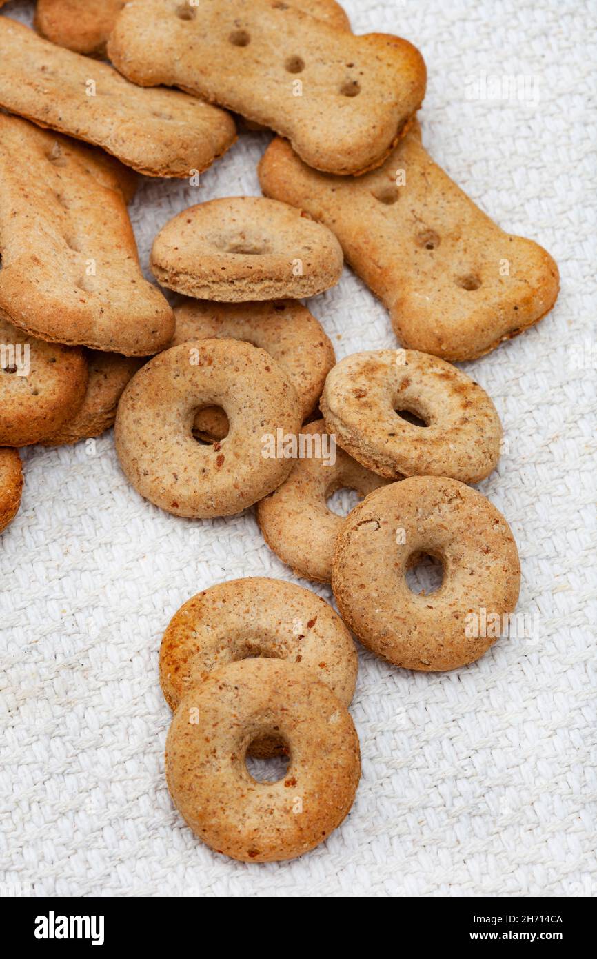 Diverse forme di biscotti per il trattamento del cane su un piano portapaziente leggero e neutro Foto Stock