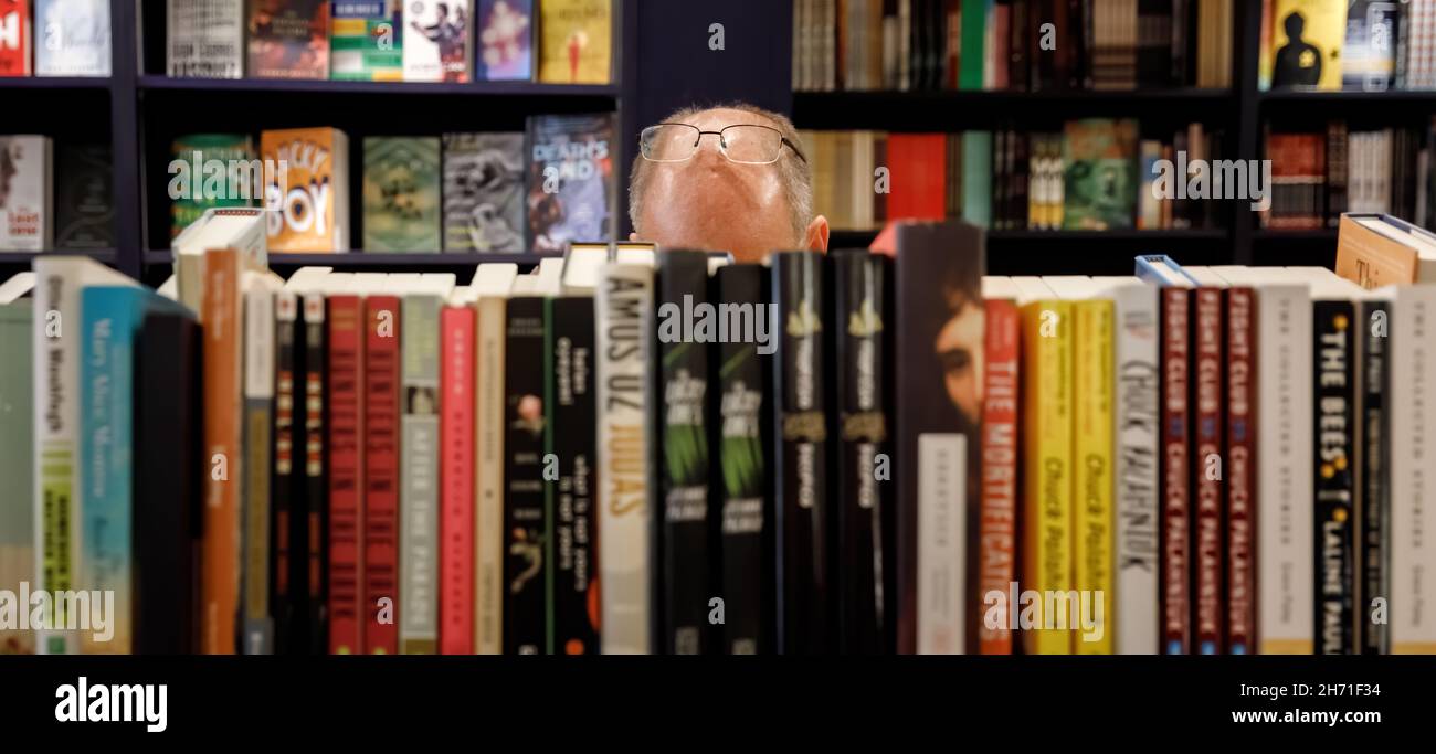 NEW YORK, USA - Sep 23, 2017: Libreria a Manhattan. Un uomo con gli occhiali sulla fronte sceglie i libri in una libreria Foto Stock