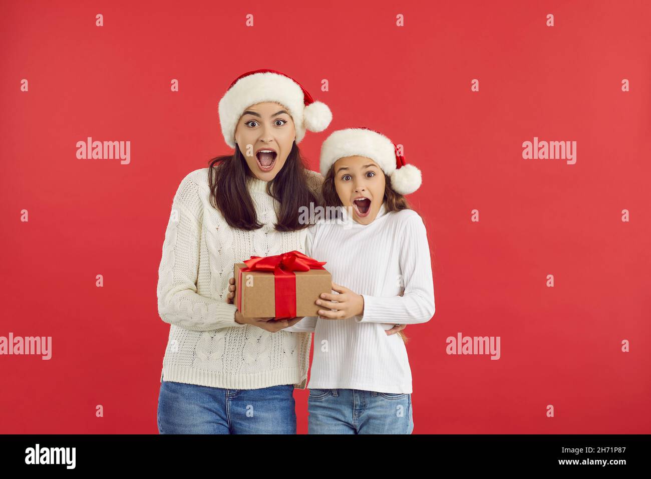 Felice madre e bambino che tiene il regalo di Natale con le espressioni del viso sorpresi Foto Stock
