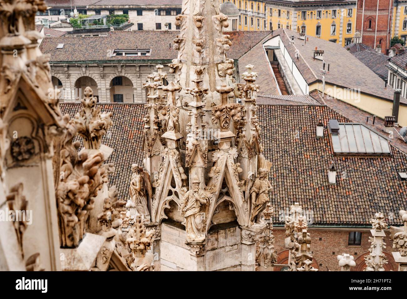 Sculture sulla guglia del Duomo sullo sfondo della città. Italia, Milano Foto Stock