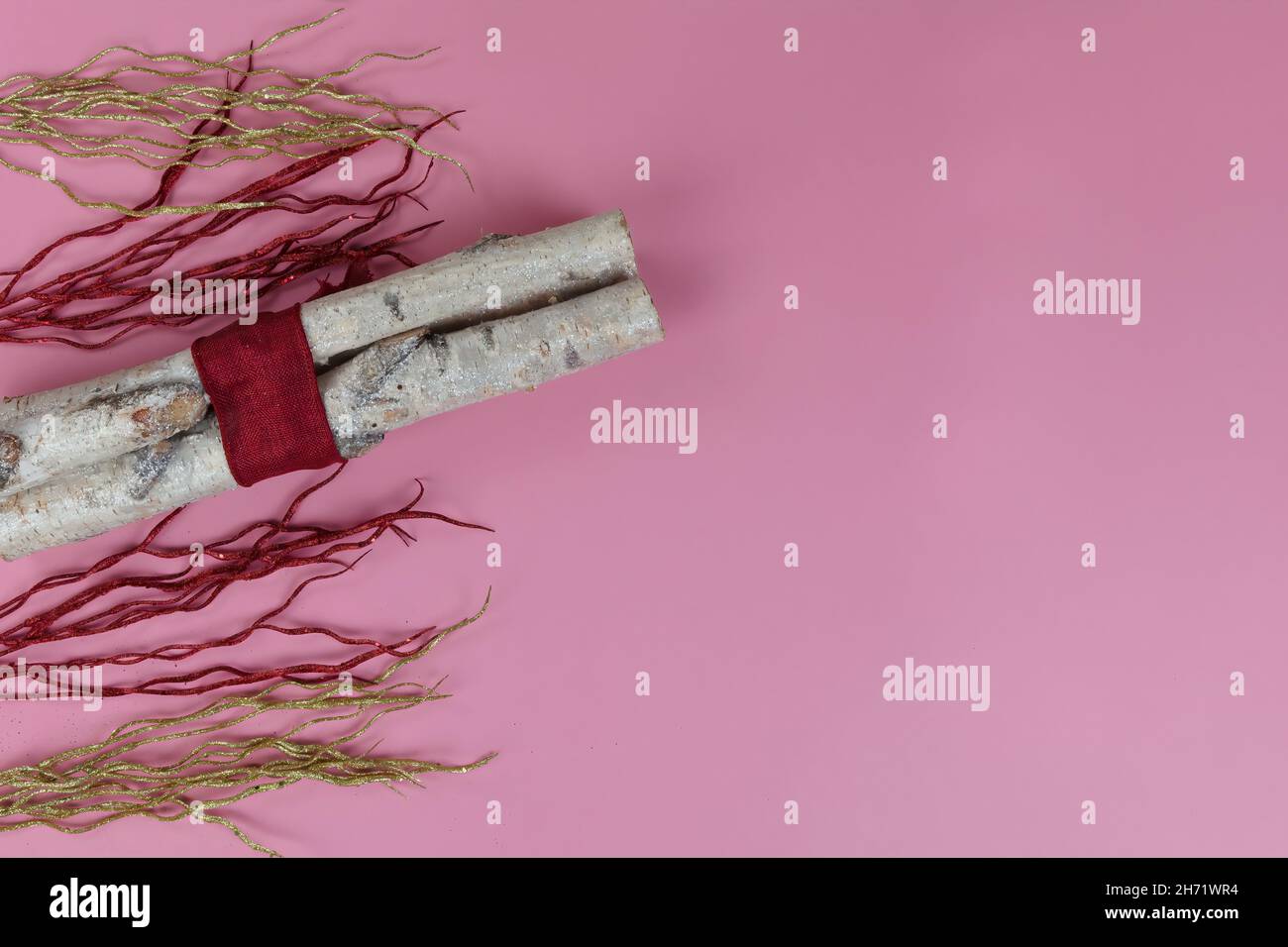 Vista dall'alto con decorazioni in oro caldo e fiamma rossa con tronchi avvolti su un ambiente rosa chiaro per un buon Natale o felice anno di sfondo Foto Stock