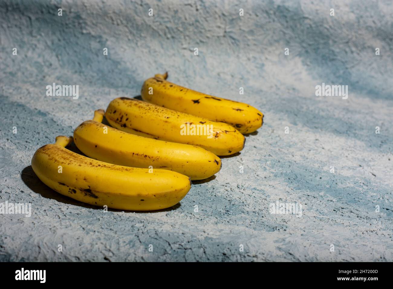 banane mature su sfondo blu Foto Stock