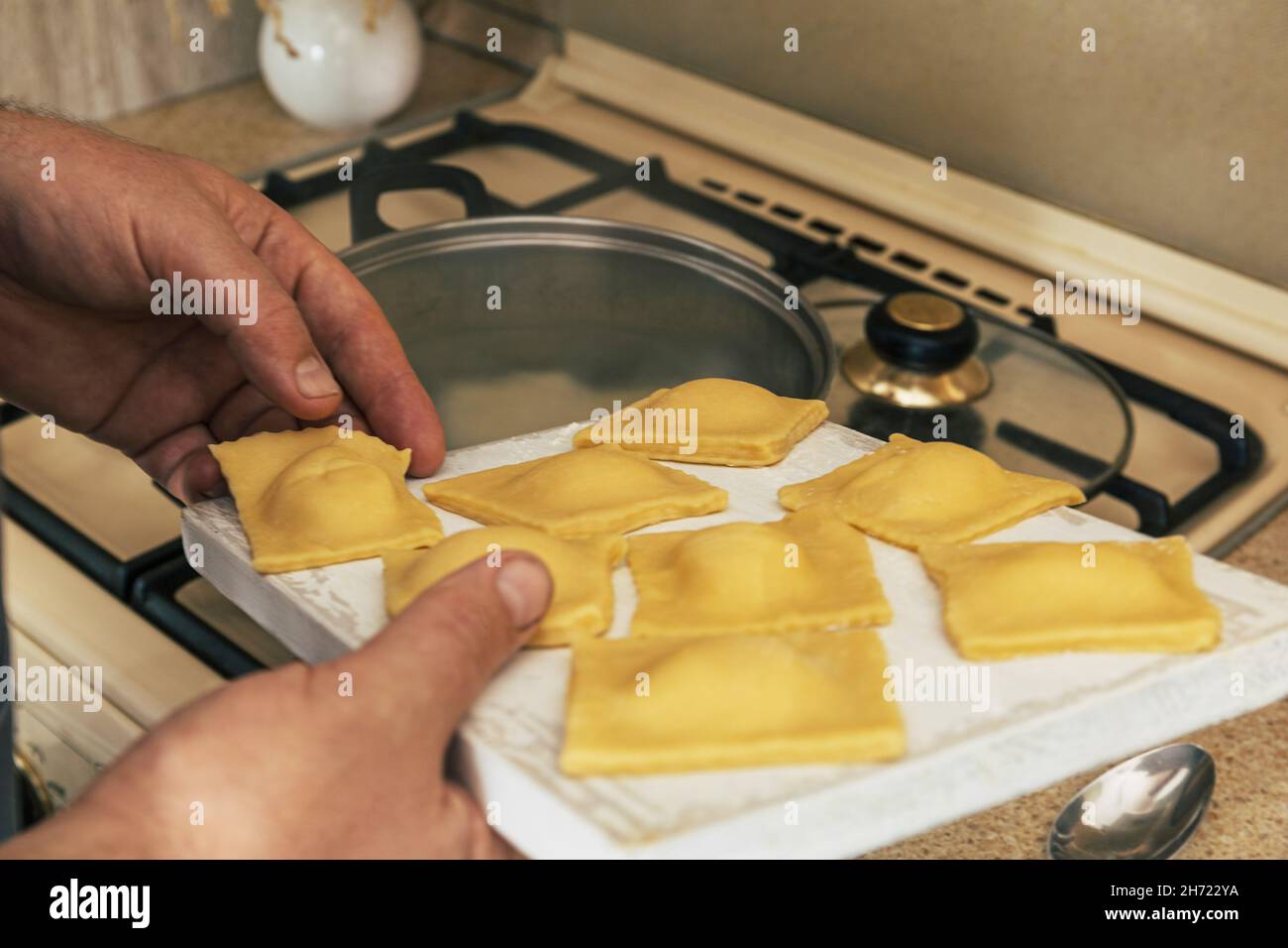 Soggiorno a casa e cucina. Ravioli di ricotta di zucca italiana fatti in casa, processo di cottura dei ravioli. Foto Stock