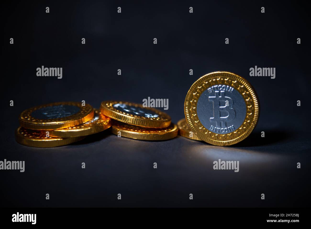 Primo piano del bitcoin d'oro su sfondo nero con messa a fuoco selettiva Foto Stock