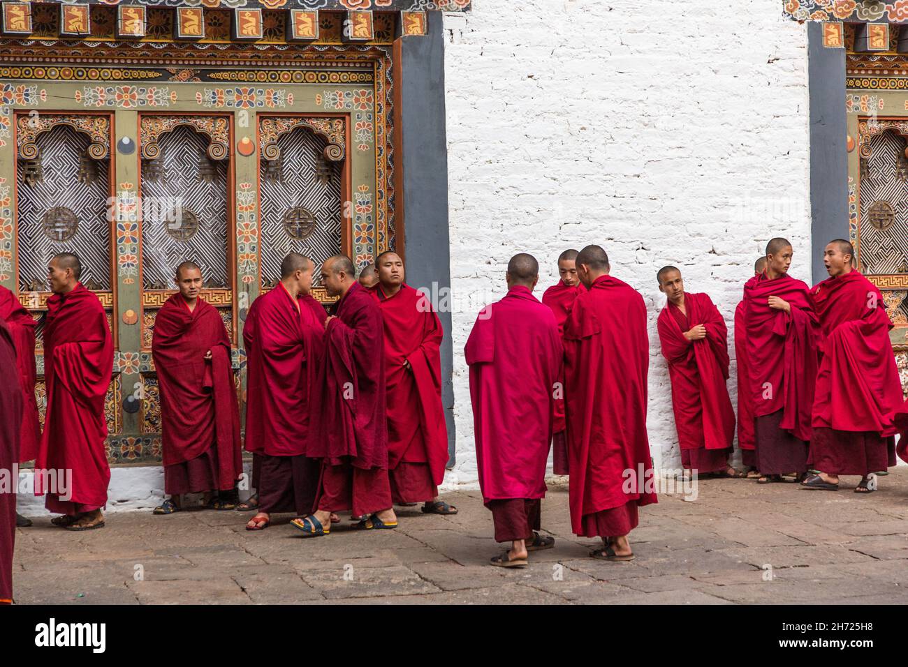 Un gruppo di monaci buddisti in un dochey o cortile nel Punakha Dzong in Punakha, Bhutan. Foto Stock