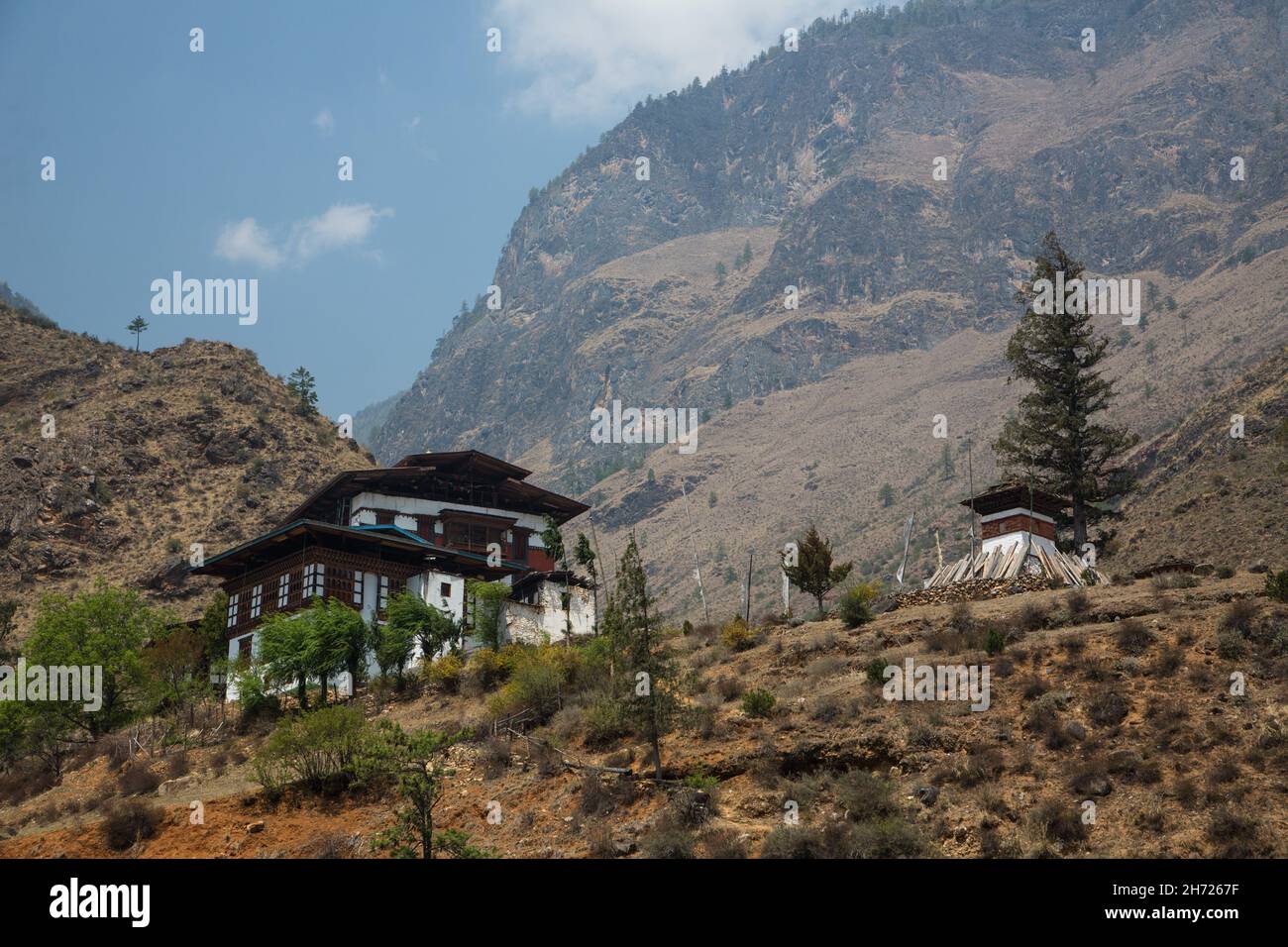 Il tempio buddista di Tamchhog Lhakhang, la fattoria e il coro a strisce rosse vicino a Paro, Bhutan. Foto Stock