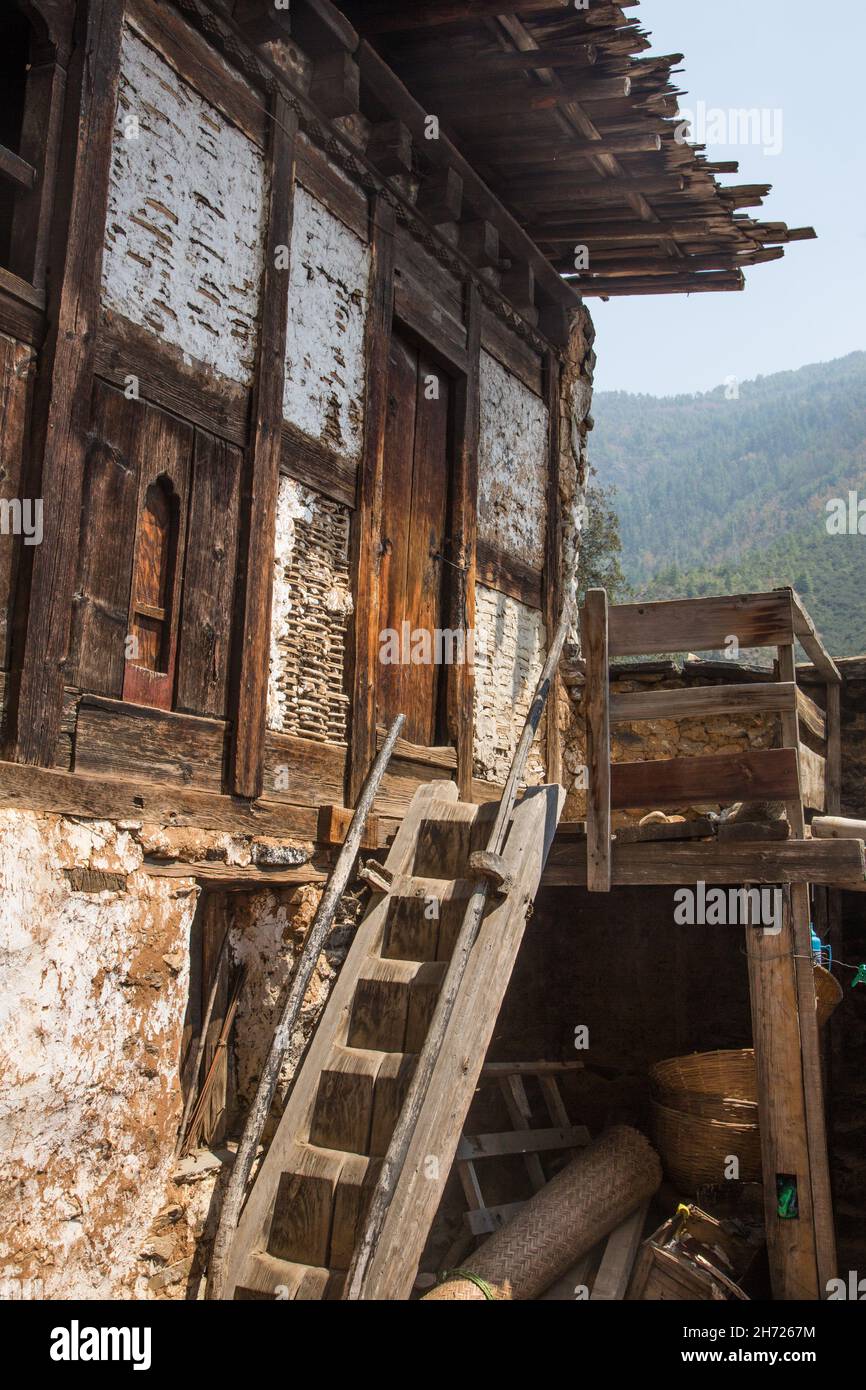 La scala in legno intagliata di una vecchia casa colonica presso il Tempio di Tamchhog Lhakhang vicino a Paro, Bhutan. Foto Stock